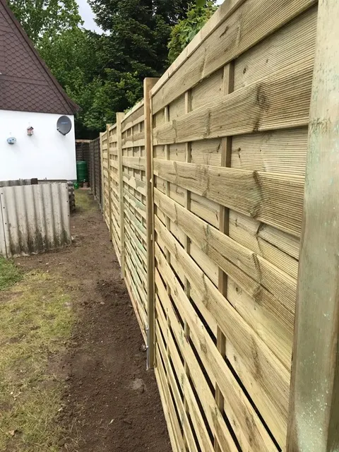 Neuer Holz-Sichtschutzzaun während der Montage